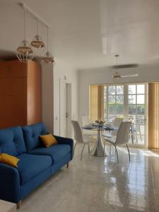 un soggiorno con divano blu e tavolo di Superior Apartment Casa Vela Albufeira S Rafael beach ad Albufeira