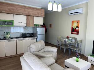 un soggiorno con divano e tavolo e una cucina di Skampini Qerret Apartments a Golem