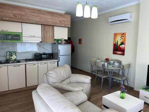 a living room with a couch and a table and a kitchen at Skampini Qerret Apartments in Golem
