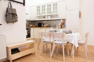 a kitchen with a dining room table and chairs at Scandi Custom 2-BDR Apartment in Budapest +17 photos