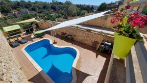 vista sulla piscina in cima a un edificio di Happy and Healthy Gozo B&B HOUSE a Victoria