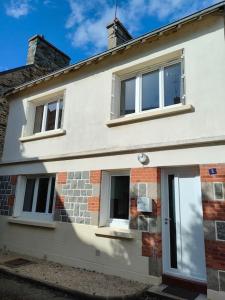 uma casa branca com duas janelas em Maison presqu'île Hillion centre bourg et proche de la Mer em Hillion