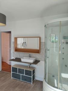 La salle de bains est pourvue d'un lavabo et d'une douche en verre. dans l'établissement Maison presqu'île Hillion centre bourg et proche de la Mer, à Hillion