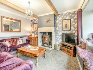a living room with a couch and a fireplace at Weavers Cottage in Marsden