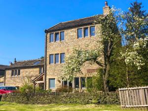 a large brick house with a stone wall at Weavers Cottage in Marsden