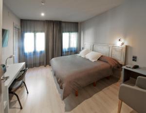 A bed or beds in a room at Hotel Jardí Apartaments