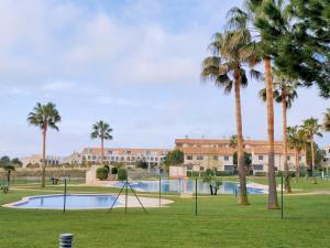 Panoramica Golf Karilo في سانت خورذي: حديقة فيها نخل ومسبح