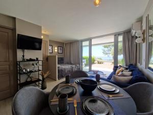 a living room with a table and chairs and a couch at Unique Apartment - Costa Plana in Cap d'Ail
