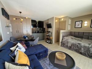 uma sala de estar com um sofá azul e uma cama em Unique Apartment - Costa Plana em Cap d'Ail