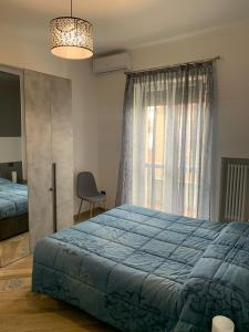- une chambre avec un lit bleu et une fenêtre dans l'établissement MIRAFIORI HOUSE, à Turin