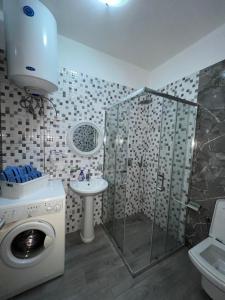 a bathroom with a washing machine and a sink at Skampini Qerret Apartments in Golem +18 photos
