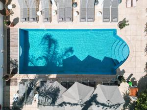 een uitzicht over een zwembad in een gebouw bij Hôtel La Villa Juan Beach in Juan-les-Pins