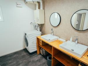 a bathroom with two sinks and a washing machine at ゲストハウスVACILANDO in Chitose +16 photos