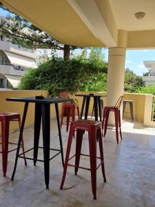 a group of tables and stools on a patio at Maria's Sharing Apartment in Heraklio