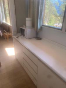 a kitchen counter with a microwave and a window at Chalet Vicino a Cortina in Borca di Cadore