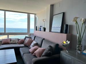 ein Wohnzimmer mit einem Sofa und einem großen Fenster in der Unterkunft ROSAS Vue sur Mer in Roses