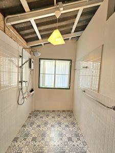 a bathroom with a shower and a window at Simple Home บ้าน-บะ-ดาย in Ban Long O