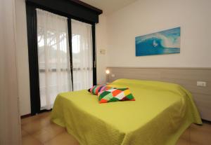 リニャーノ・サッビアドーロにあるResidenza La Meridianaのベッドルーム1室(黄色のベッド1台、枕付)