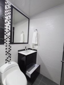 y baño con lavabo, aseo y espejo. en New comfortable house at Paipa close to everything great location, en Paipa