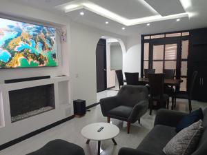 uma sala de estar com uma grande televisão na parede em Comoda casa para descansar en Paipa & excelente ubicacion em Paipa