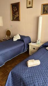 2 camas en una habitación con sábanas azules y una mesa en camera Santa Rita, en Turín