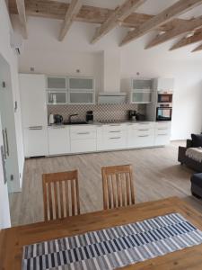 a kitchen with white cabinets and a table and chairs at Constanza in Plau am See