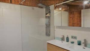 a white bathroom with a sink and a shower at AlpinResort DerBacherhof in Niedernsill