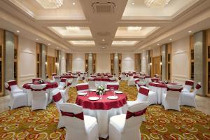 卡绍利Cassia Resort, Kasauli的宴会厅配有红色和白色的桌椅