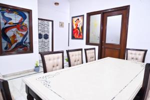 une salle à manger avec une table et des chaises blanches dans l'établissement Hotel Wild Rose, à New Delhi