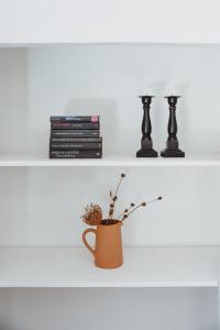 ein weißes Regal mit Vase und Büchern in der Unterkunft Finca Viva la Vida in Alora