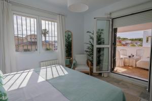 a bedroom with a bed and a large window at GINVA - Villa Puerto Sherry in El Puerto de Santa María