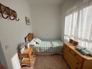 a bedroom with a bed and a dresser and a window at Apartamento ideal familias in Playa de Gandia