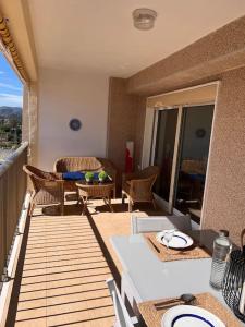 Apartamento ideal familias في Playa de Gandia: شرفة مع طاولة وكراسي على السطح