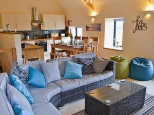 a living room with a couch and a kitchen at Pen Yr Allt in Rhosneigr