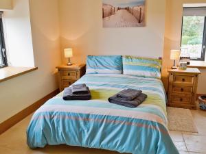 a bedroom with a bed with towels on it at Pen Yr Allt in Rhosneigr