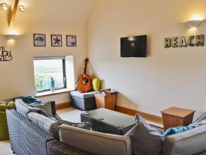 a living room with two couches and a flat screen tv at Pen Yr Allt in Rhosneigr