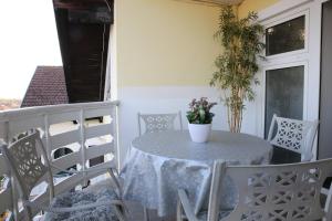 a table on a balcony with a vase of flowers on it at Sobe Opačak in Slavonski Brod