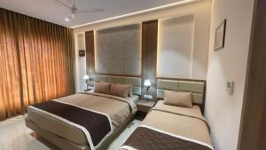 una habitación de hotel con 2 camas en una habitación en HOTEL VAHINI GRAND, en Bhavāni