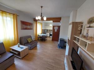 uma sala de estar com um sofá e uma mesa em Apartman Rozmari em Lokve