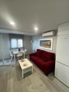 salon z czerwoną kanapą i stołem w obiekcie Beach front Esther 1 villajoyosa w mieście Villajoyosa