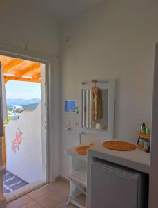 a bathroom with a sink and a mirror at Georgia Rooms Milos in Plaka Milou