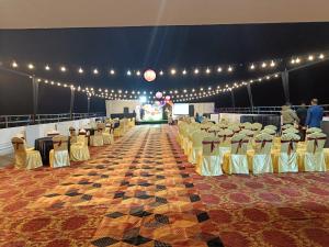 ディブルガルにあるHOTEL GOLDEN ORCHIDの椅子と照明が並ぶ宴会場