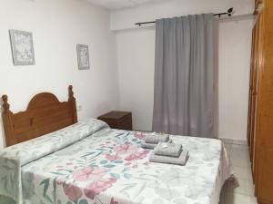 una camera da letto con un letto con copriletto floreale di La redonda a San Roque
