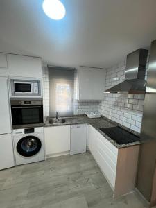 a kitchen with white cabinets and a washer and dryer at Beach front Esther 1 villajoyosa in Villajoyosa
