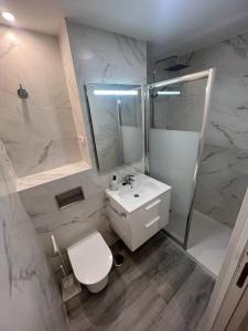 een witte badkamer met een toilet en een wastafel bij Beach front Esther 5 Villajoyosa VACATION RENTALS FROM 11 NIGHTS in Villajoyosa