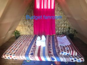 a bed in a tent with a red curtain at Bayview Coron Kawa Resort in Coron