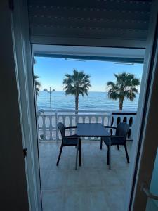 a view of the ocean from a balcony with a table and chairs at Beach front Esther 5 villajoyosa in Villajoyosa