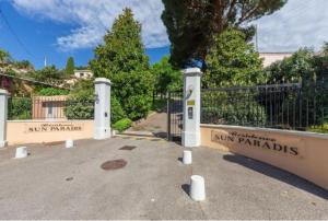 uma cerca com duas entradas para um quintal com árvores em Résidence de luxe Sun Paradis, Studio terrasse, vue Mer Piscine em Cannes