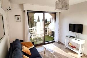 uma sala de estar com um sofá e uma grande janela em Résidence de luxe Sun Paradis, Studio terrasse, vue Mer Piscine em Cannes