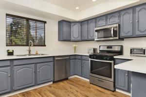 een keuken met blauwe kasten en roestvrijstalen apparatuur bij 2169-Whispering Forest Chalet chalet in Big Bear City